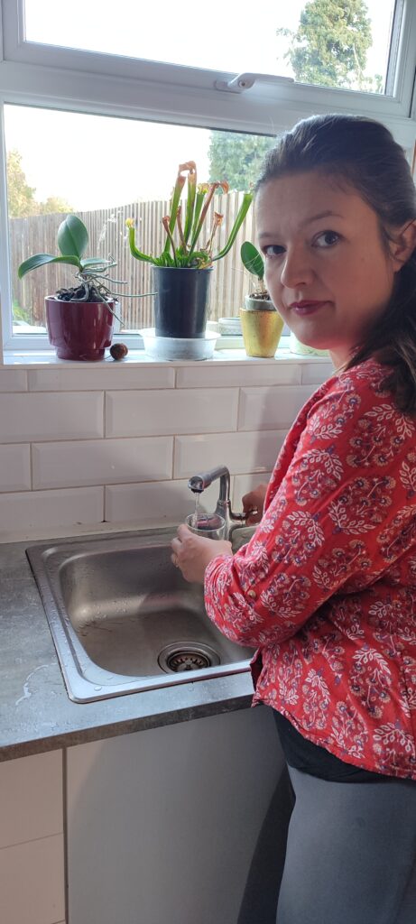 Sarah Nicmanis fills a glass with water at her kitchen sink